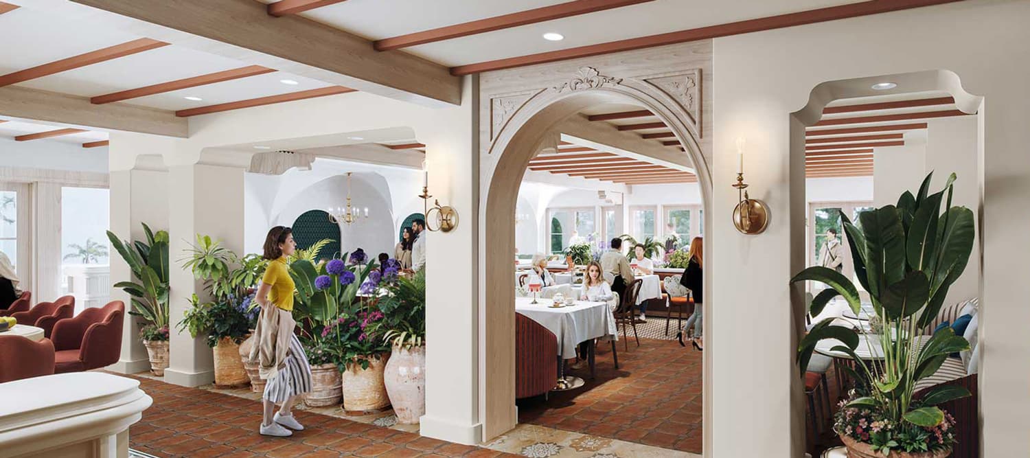 Elegant restaurant interior with an arched doorway, lush plants, and people dining at tables.